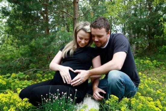 mujer embarazada con esposo en el bosque